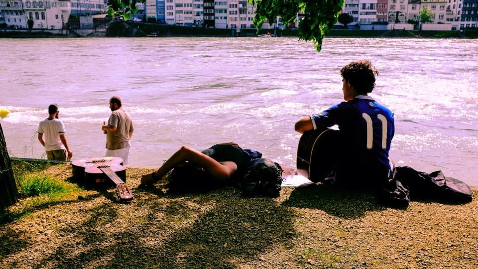 Menschen sitzen gemütlich am Fluss