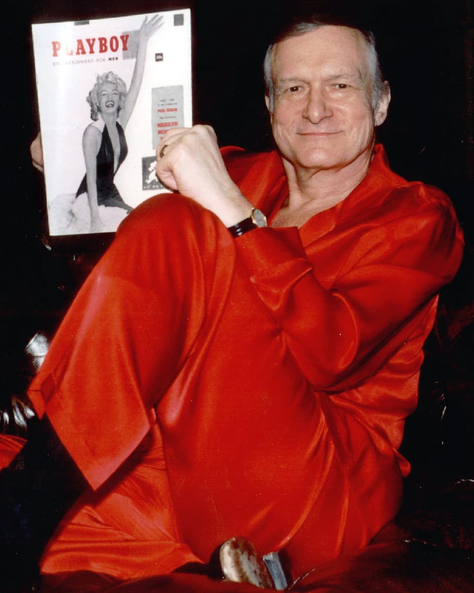 Mann in rotem Satinpyjama mit Magazin
