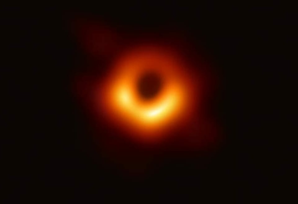 Grosser leuchtender, orangefarbiger Ring mit schwarzem Schatten in der Mitte.