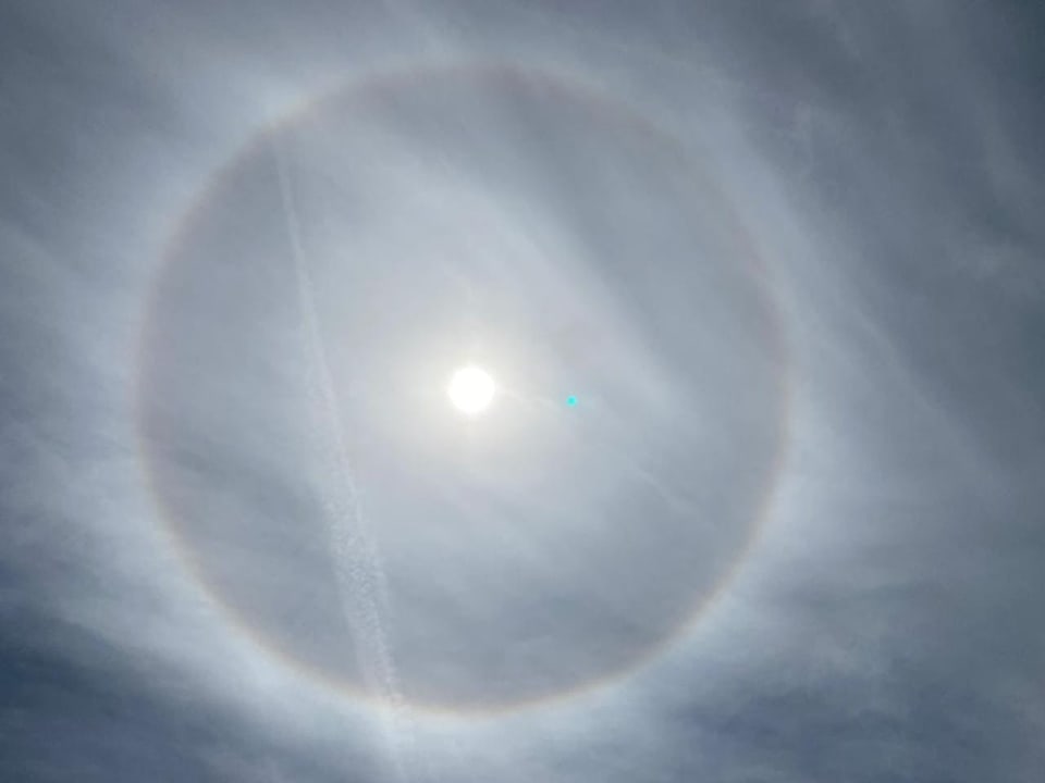 Regenbogen-Ring um die Sonne am milchigen Himmel