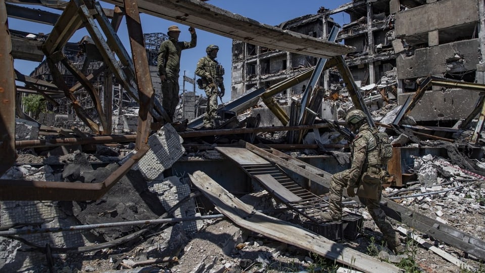 Russische Soldaten auf Ruinen.