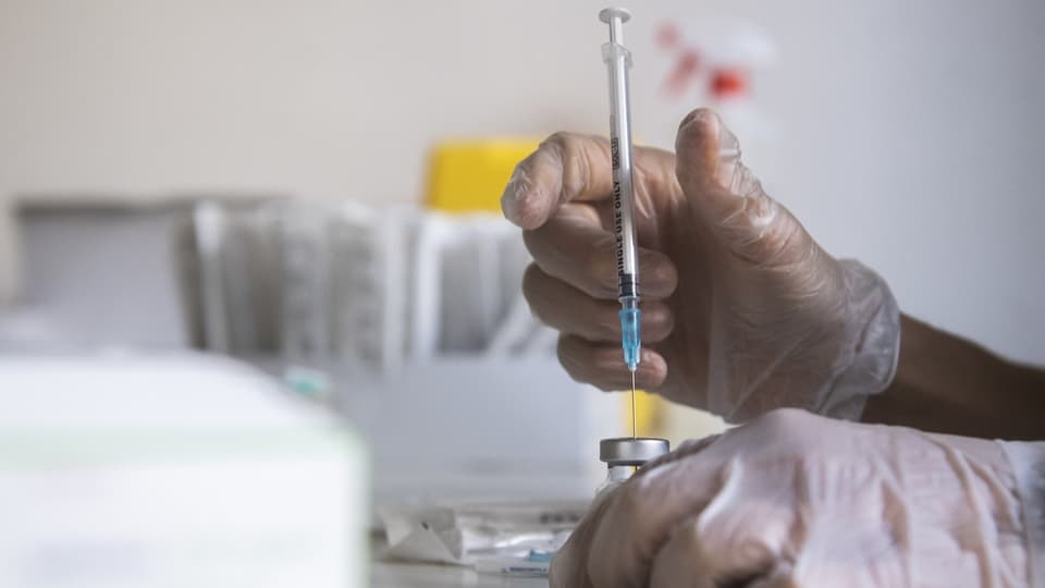 Eine Dosis Impfstoff wird auf eine Spritze gezogen.