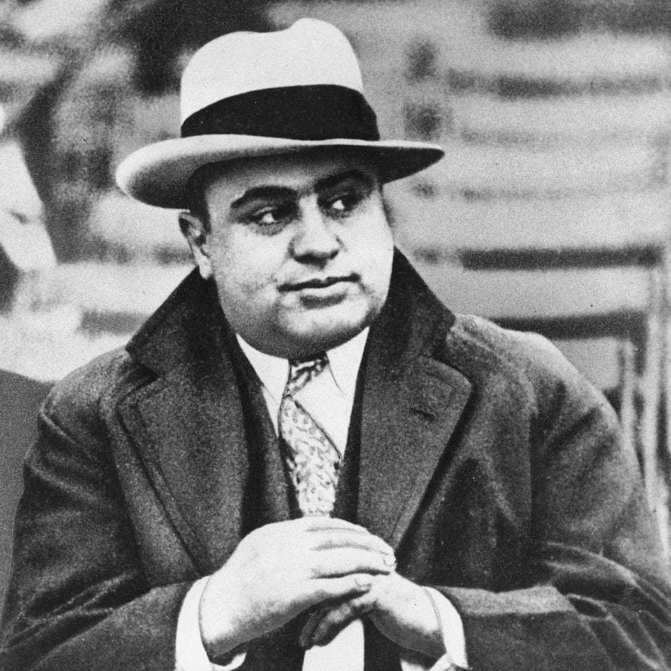 Gangsterboss Al Capone mit Hut und Mantel.