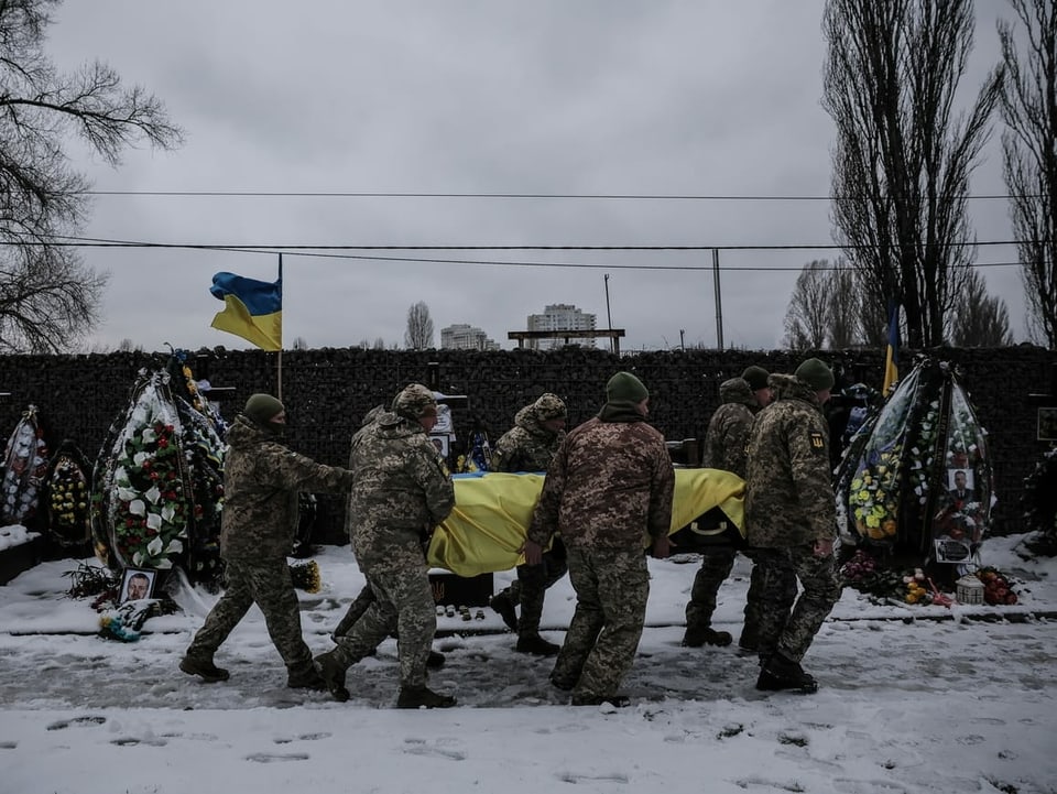 Kameraden tragen den Sarg des ukrainischen Soldaten Serhij Pawllichenko auf einem Militärfriedhof in Kiew. 