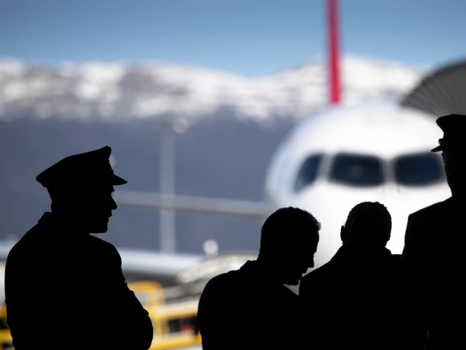 Swiss-Piloten stehen vor einem Flugzeug.