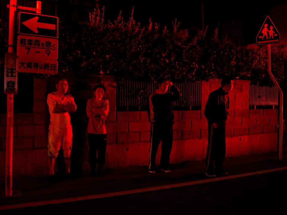 Vier Menschen stehen am Strassenrand