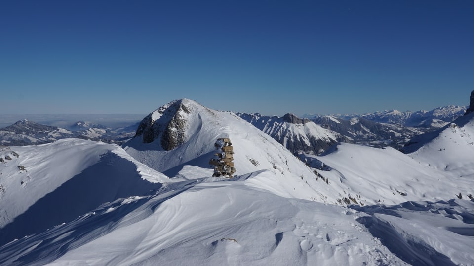Blick über die schneebedeckten Berge des Berner Oberlandes bei wolkenlosem Himmel.