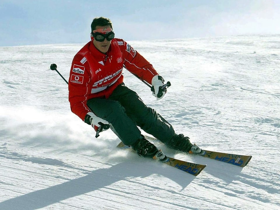 Schumacher trägt hier einen rot-schwarzen Skianzug ohne Helm. 