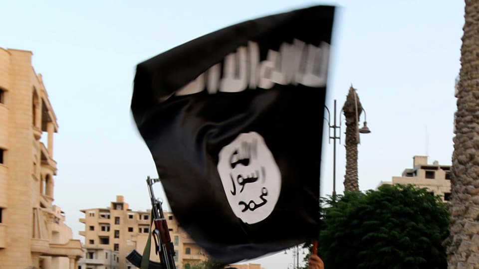  Ein IS-Aktivist schwenkt eine schwarze Flagge der Dschihadisten.