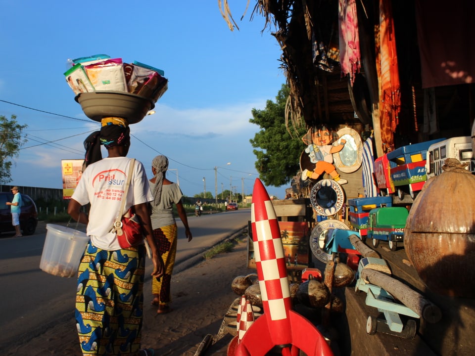 Holzwaren, bunte Stoffe, Gemälde, Erdnüsse – ein Souvenirstand in der Elfenbeinküste.