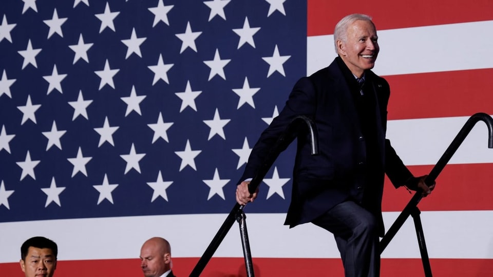 Joe Biden vor einer riesigen USA-Flagge.