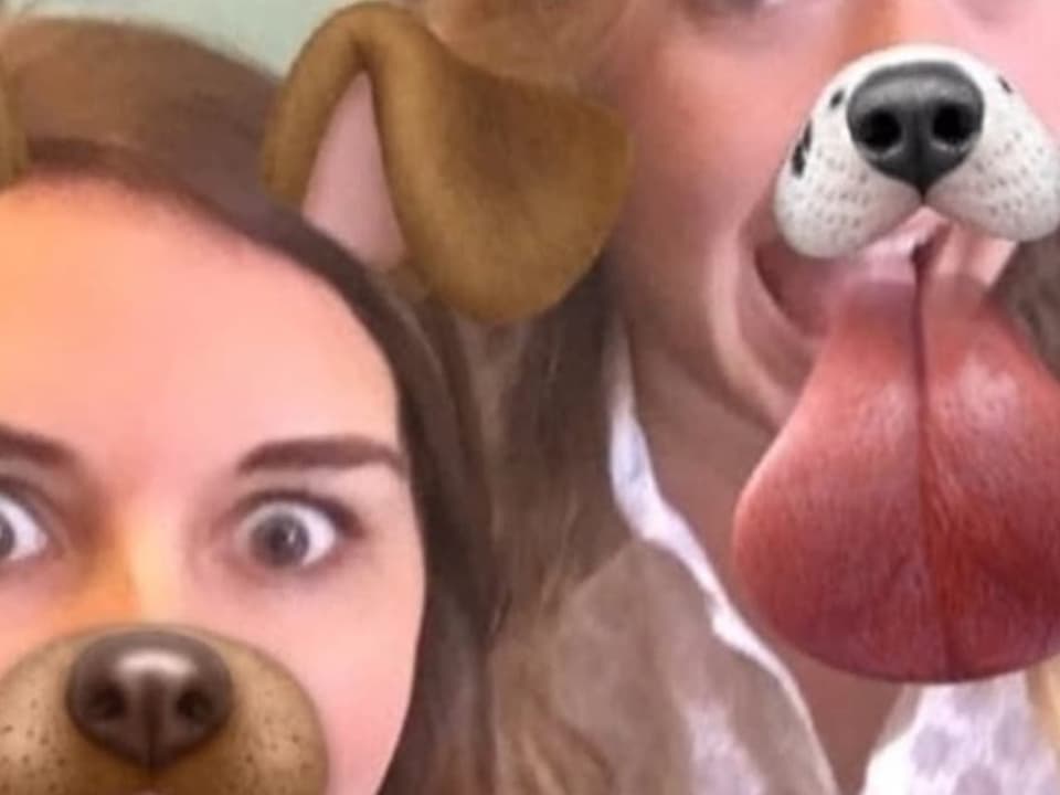 Zwei Frauen mit digital hinzugefügten Hundeohren, Schnauzen und Zungen.