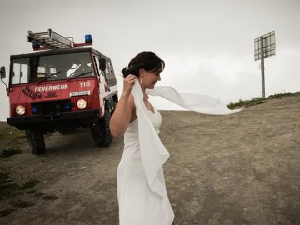 Braut auf Berg, im Hintergrund: Feuerwehrauto