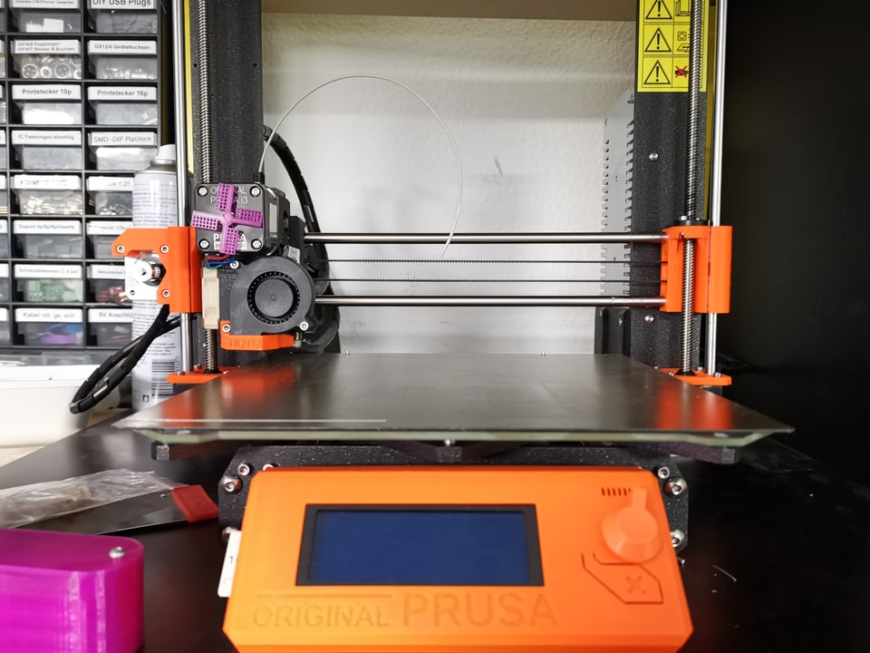 Ein 3D-Drucker mit oranger Steuer-Einheit.