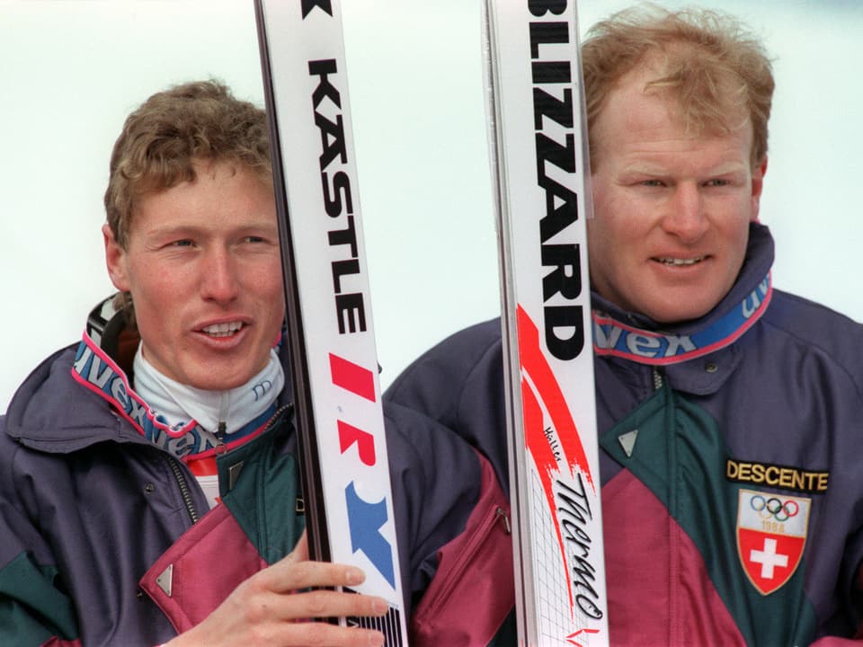 Pirmin Zurbriggen und Peter Müller posieren mit ihren Skiern fürs Foto.