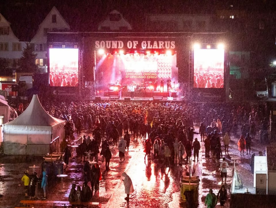 Blick auf die Bühne während Konzert von Clueso mit Publikum vorne und Regen