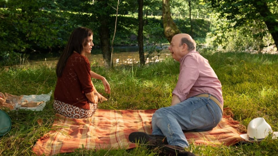 Ein älterer Mann und eine Frau beim Picknick im Park. 