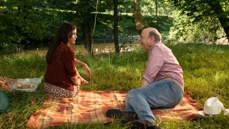 Ein älterer Mann und eine Frau beim Picknick im Park.