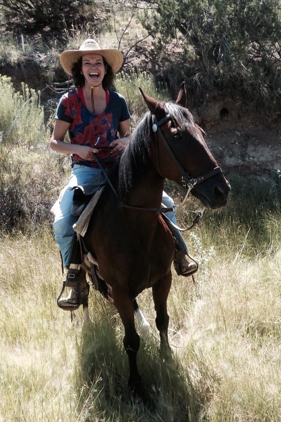 Milena Moser mit Cowboyhut und einem braunen Pferd. 