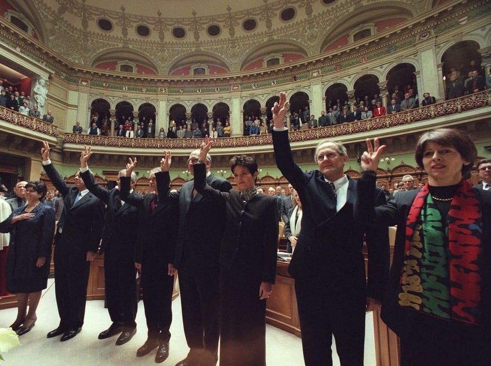 Im Nationalratssaal. Bundesratsmitglieder und Huber-Hotz, sekundiert von Weibel, erheben die Hand zum Schwur.