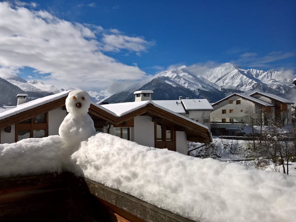 Ein kleiner Schneemann sitzt auf dem Balkongeländer. Er passt perfekt in die Schneelandschaft von Vella.