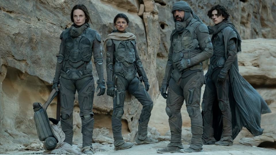 Rebecca Ferguson, Zendaya, Javier Bardem und Timothée Chalamet in Schutzanzügen auf Dune, dem Wüstenplaneten.