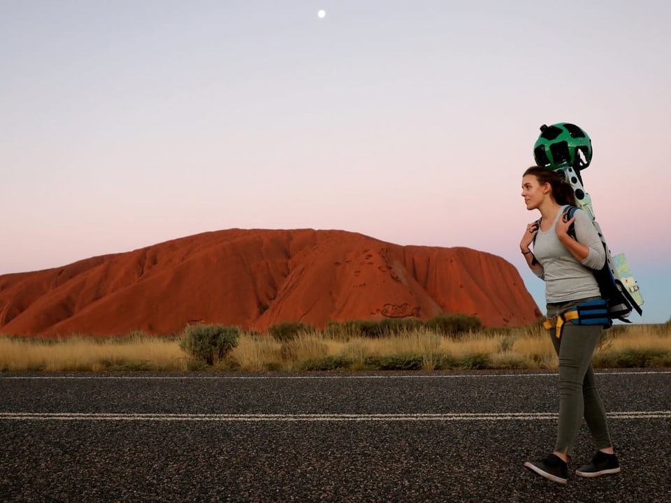 Frau mit Google-Kamera läuft vor Uluru.