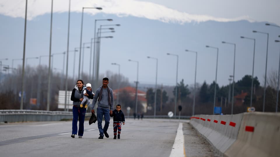 Vierköpfige Flüchtlingsfamilie zu Fuss auf einer Strasse an der griechisch-bulgarischen Grenze.