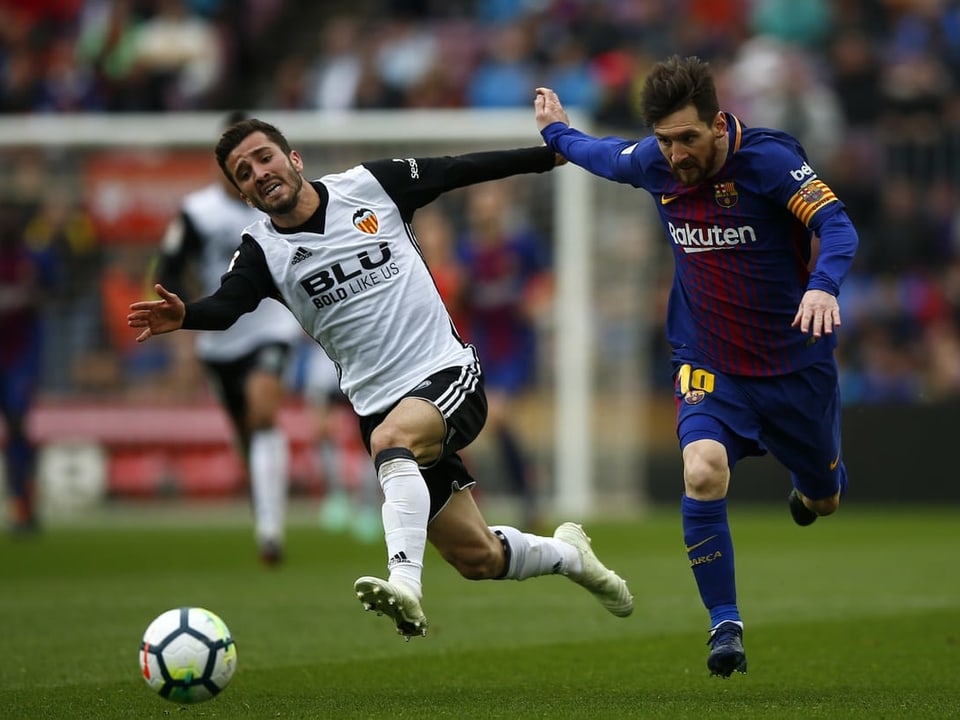 Valencias Jose Luis Gaya im Laufduell mit Barcelonas Lionel Messi.