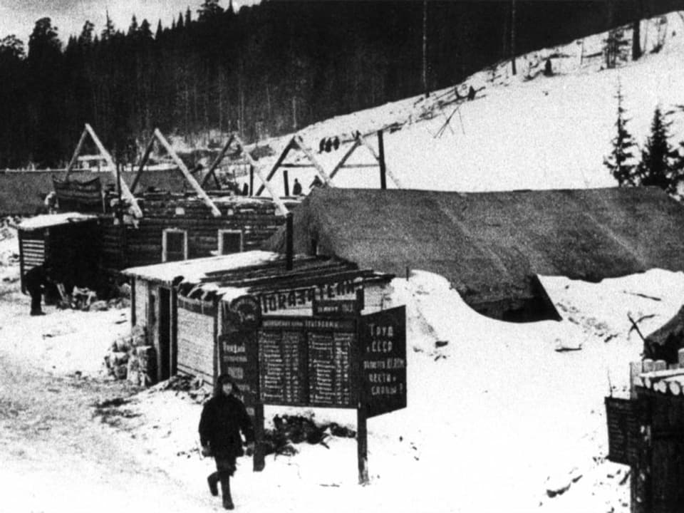 Schwarz-Weiss Bild eines Gulags von aussen.