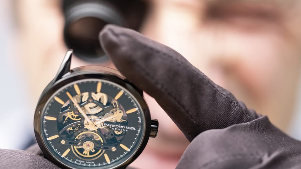 Ein Uhrenmacher fertigt gerade eine Uhr an.