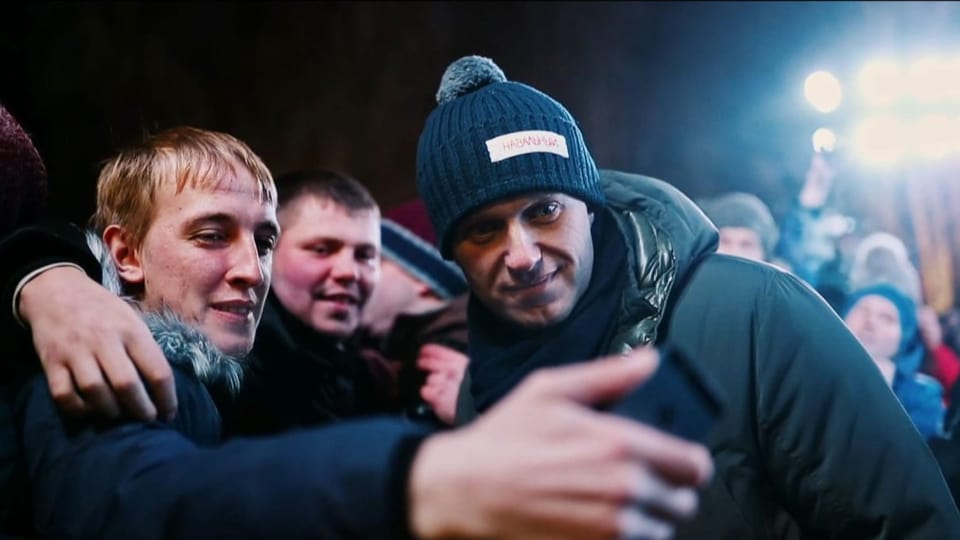 Ein Mann mit Kappe und ein junger Mann machen ein Selfie.