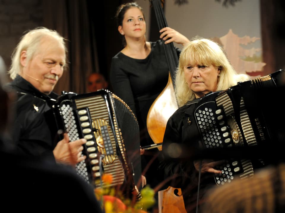Ruedi und Heidi Wachter spielen Akkordeon, im Hintergrund ist Martina Rohrer am Kontrabass