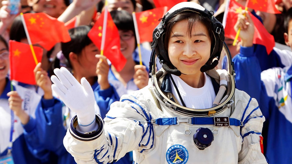 Liu Yang im Astronautenanzug winkt der jubelnden Menge zu.