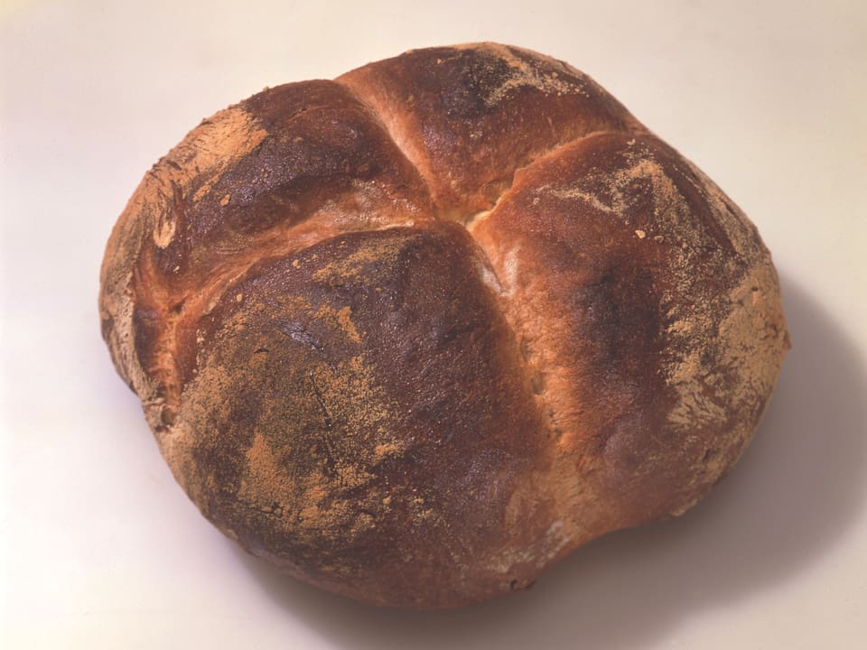 Ein rechteckiger Laib dunkel gebackenes Brot.