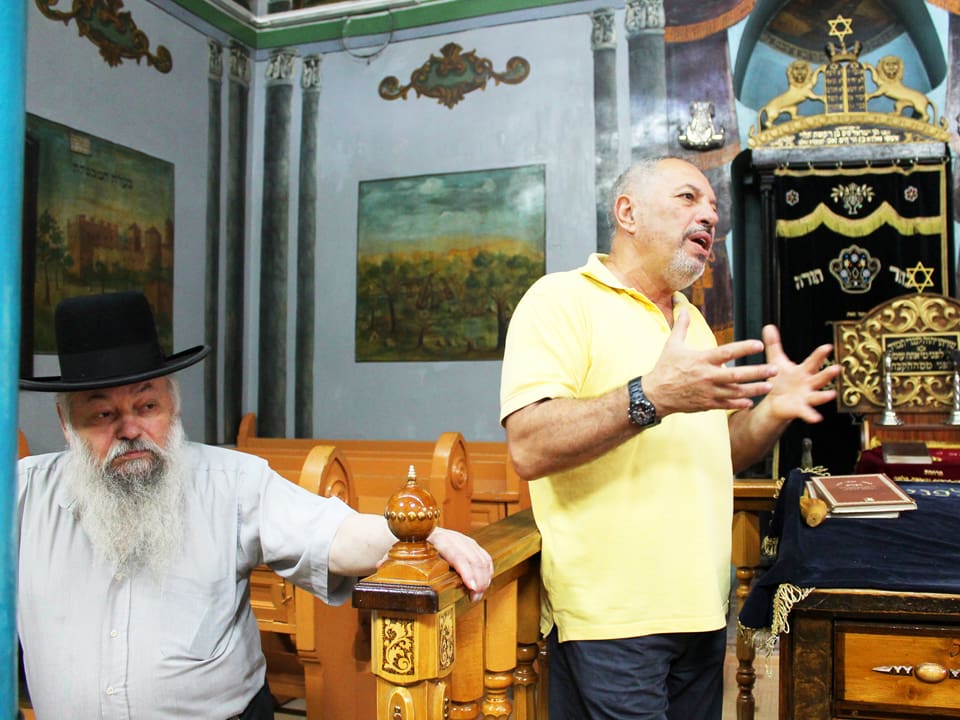 Der Gemeindevorsteher von Cernowitz steht neben dem Rabbiner.