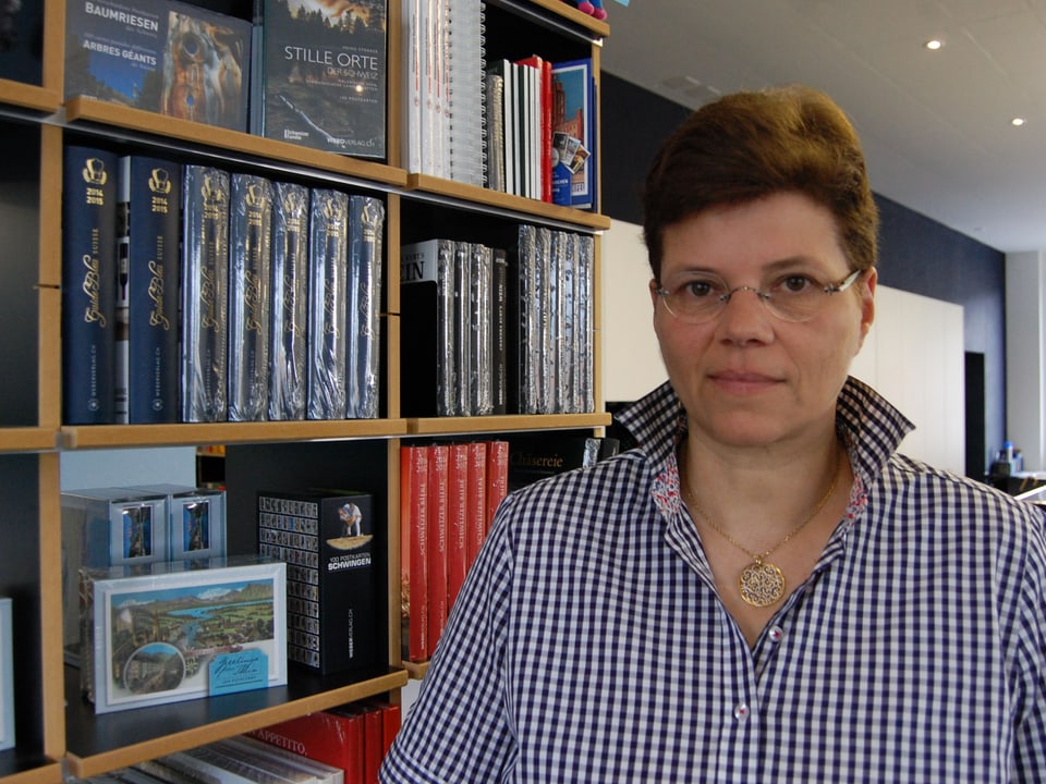 Annette Weber in ihrem Verlagshaus in Thun vor der Bücherwand.