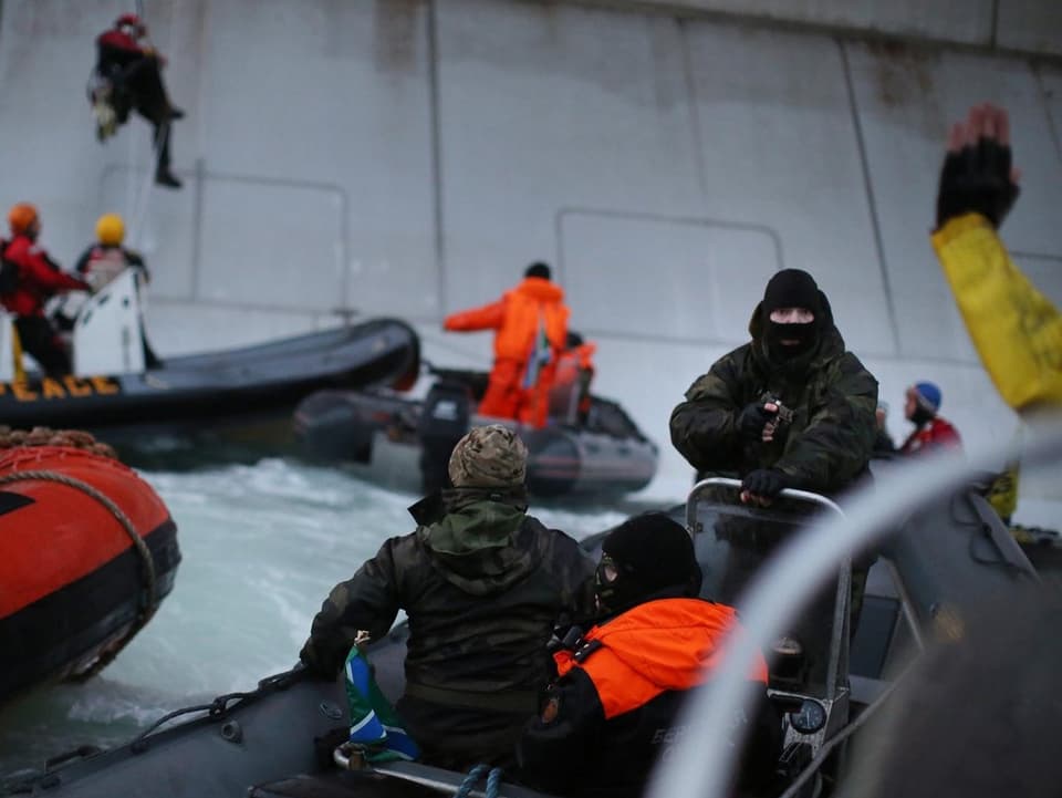 Russische Soldaten nehmen Greenpeace-Aktivisten auf Schlauchbooten fest.