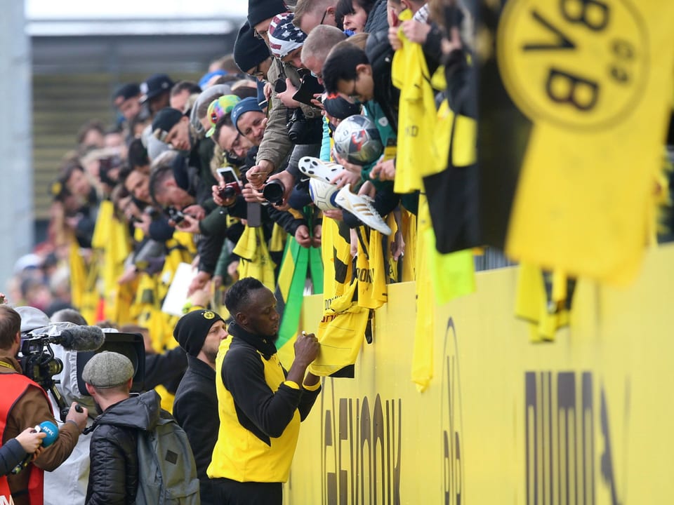 Usain Bolt erfüllt nach dem BVB-Training Fan-Wünsche.