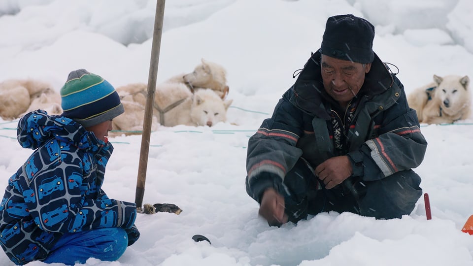 Auf dem Bild ist der kleine Junge Asser mit seinem Grossvater beim Eislochfischen zu sehen.