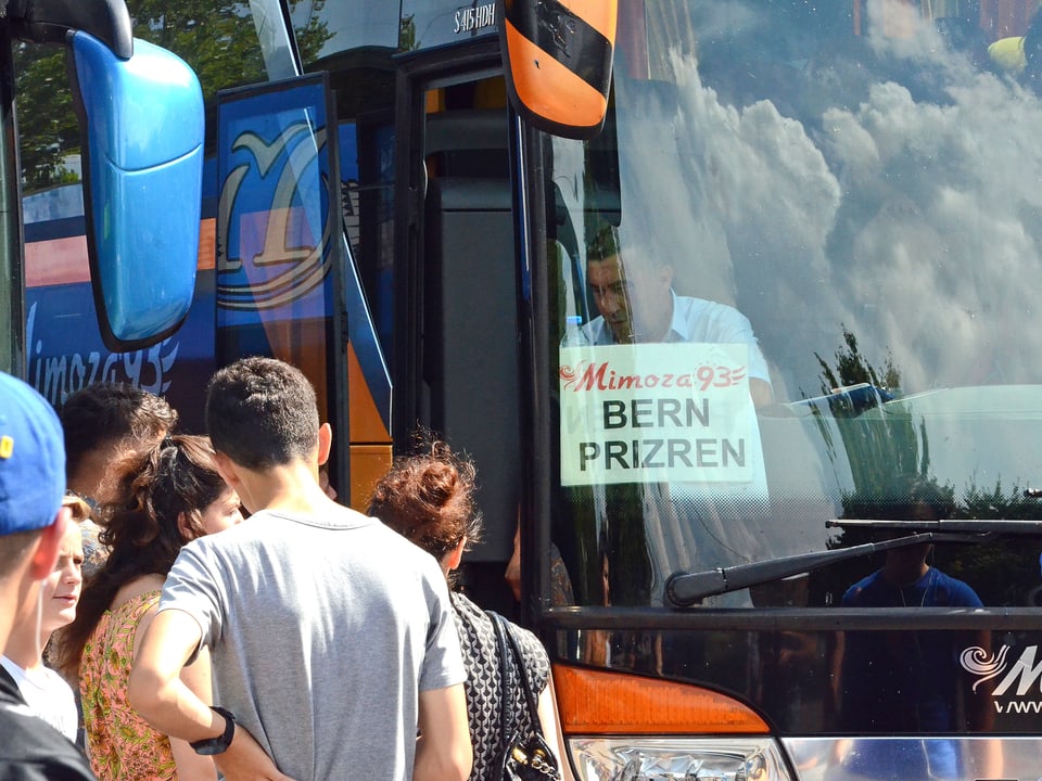 Reisende steigen in einen Bus nach Kosovo.