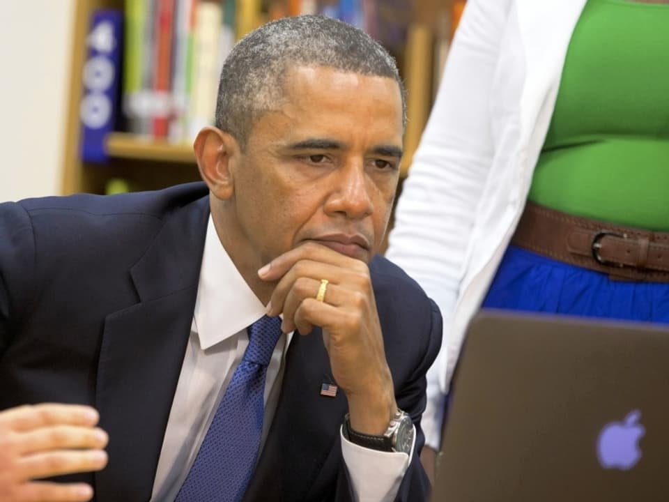 Obama liest in einem Mac Book.