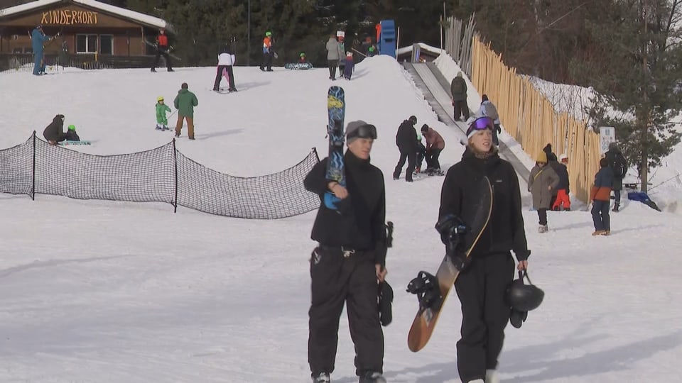 Ein Mann mit Ski und einer mit Snowboard.