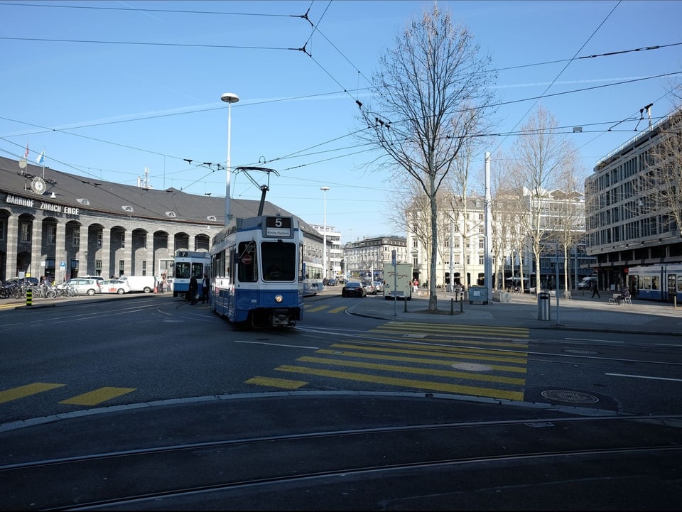 Blick auf den Bahnhofplatz mit mehreren blau-weissen Trams.