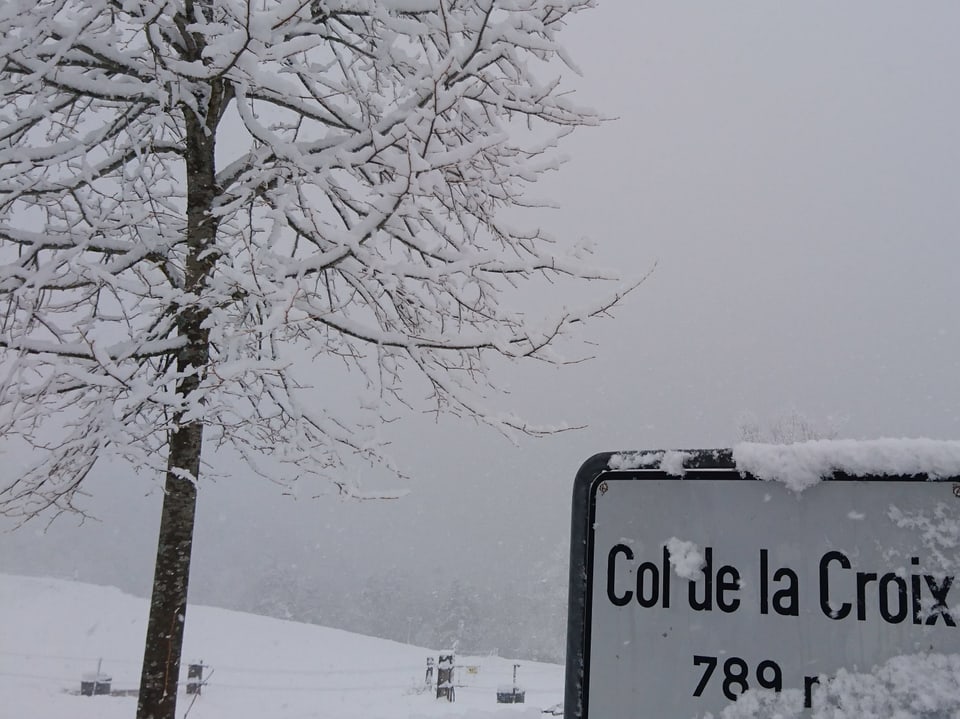 Schneelandschaft am Jura mit Ortschild.