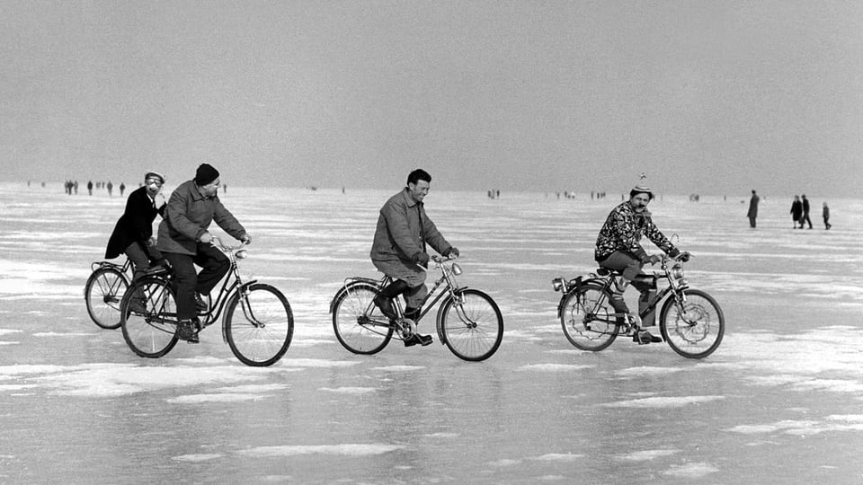 Altes Schwarzweiss-Bild von 4 Radfahrern auf dem zugefrorenen Bodensee.