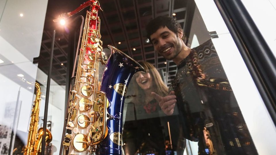 Besucher einer Saxofon-Ausstellung bewundern Exponate