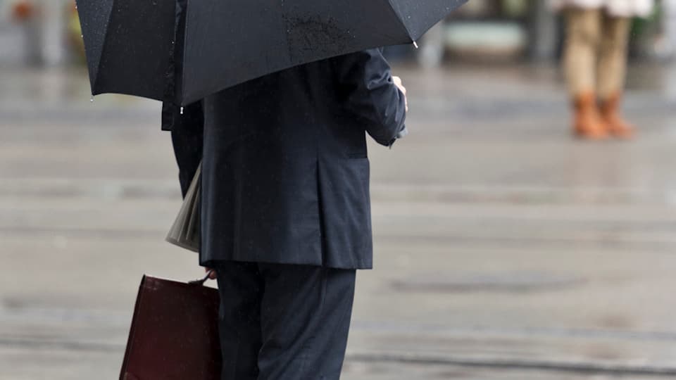 Banker in Zürich mit Schirm.