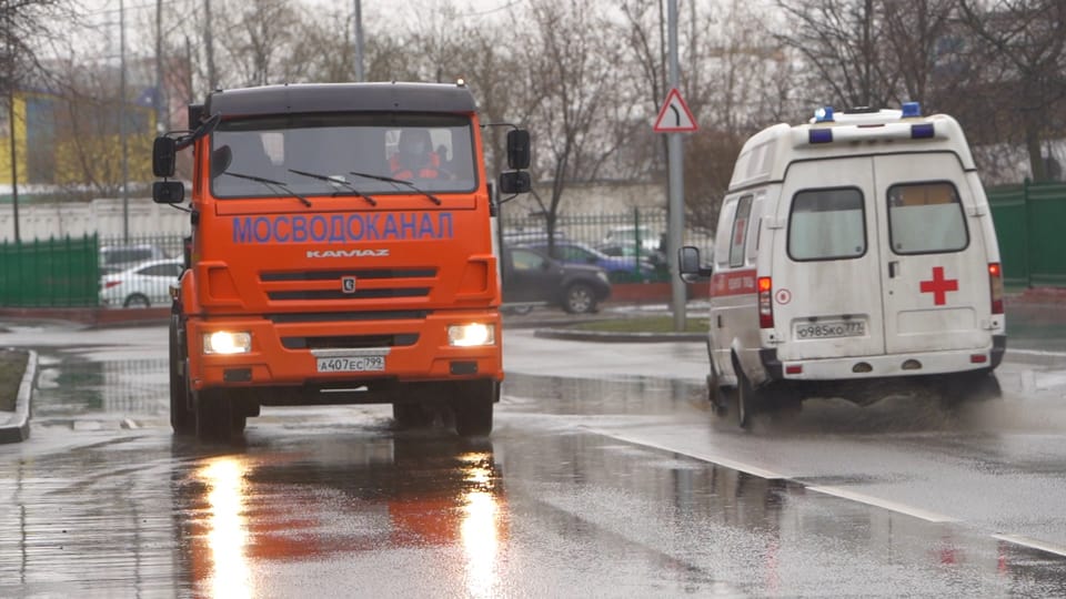 Ein Lastwagen der Moskauerabwasserbehörden links im Bild kommt einem Krankenwagen entgegen.