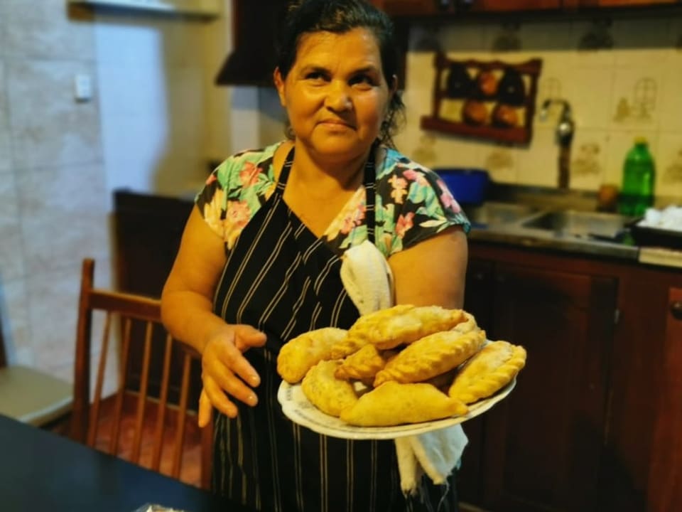 Frau zeigt Empanadas.